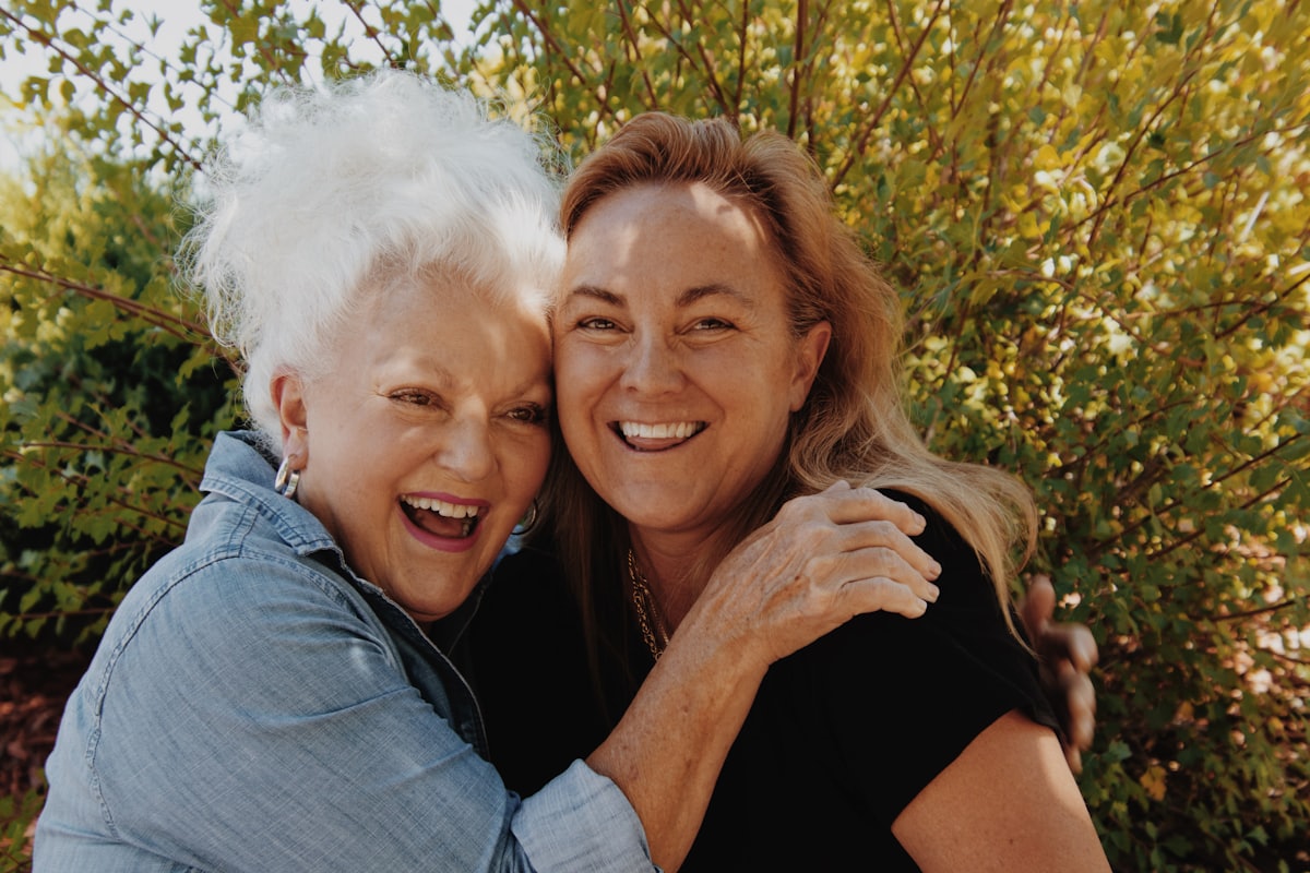 Une mère âgée et sa fille adulte, complices et souriantes